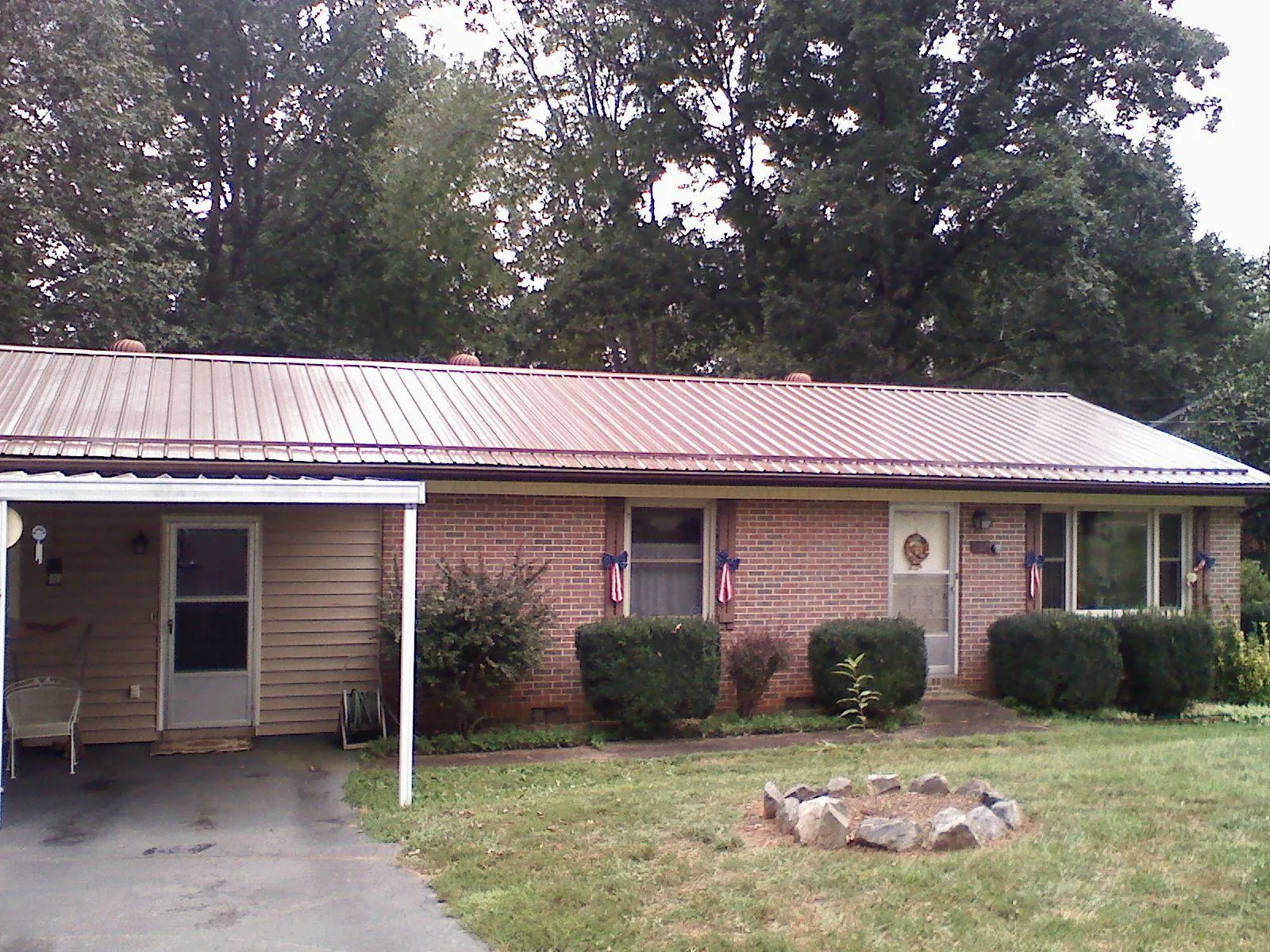 Bronze metal roof and carport on a brick ranch home — Roof Repair work by our crew in Colman